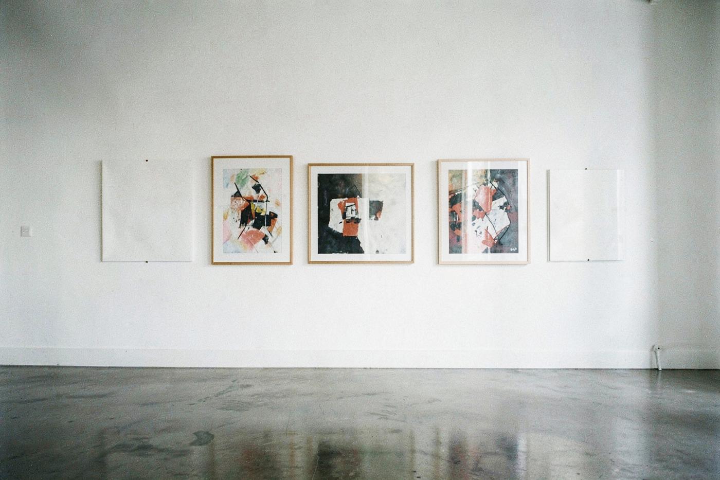 Contemporary gallery wall with framed works and concrete floor